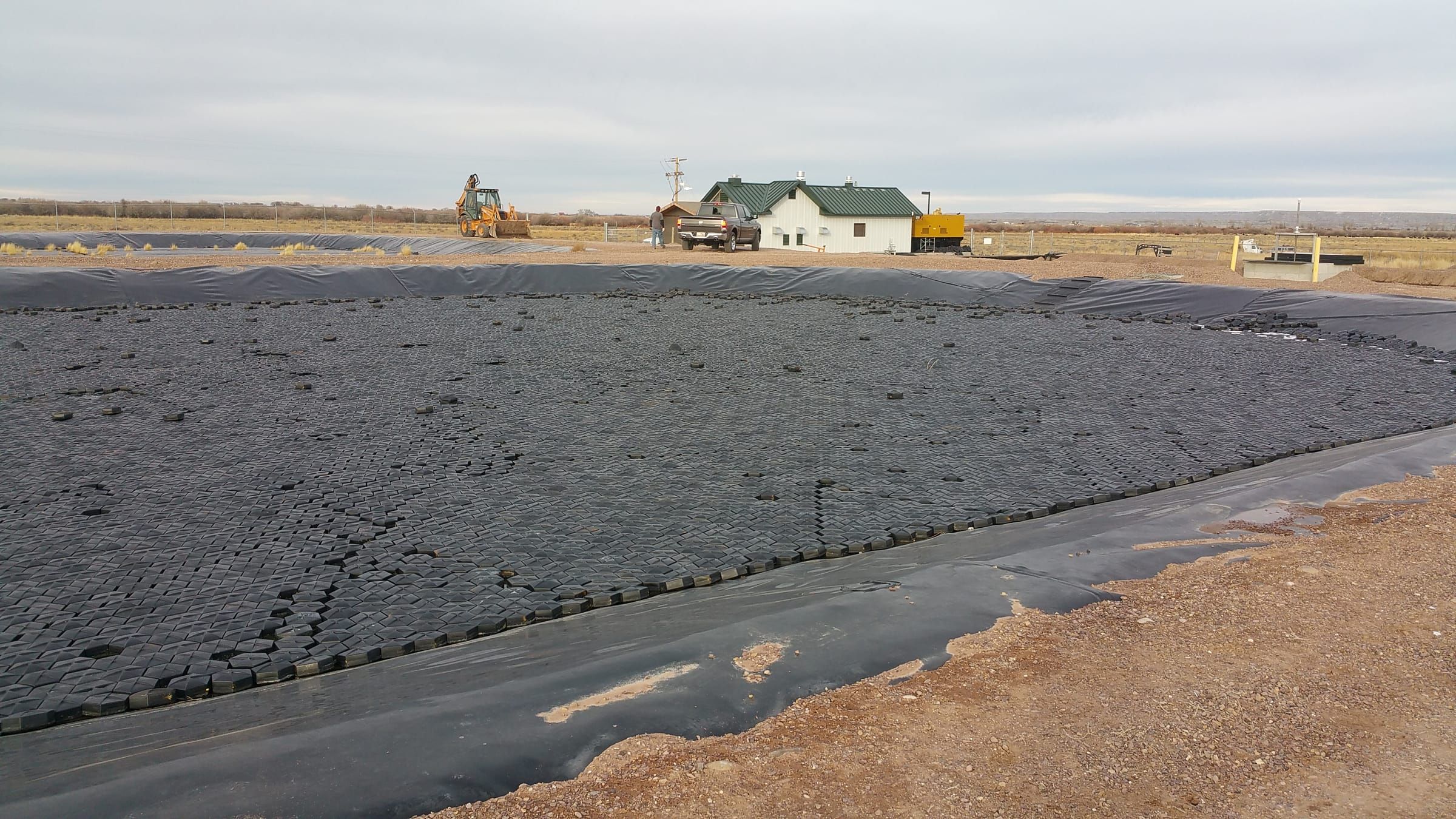 Aerial view of a large industrial water reservoir fully covered by AWTT Hexprotect modular floating cover tiles, eliminating evaporation and blocking algae growth