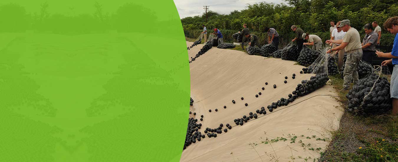 Armor Ball hollow HDPE sphere floating covers densely deployed across an industrial water storage pond providing 91% surface coverage for evaporation control, algae suppression, and odor reduction