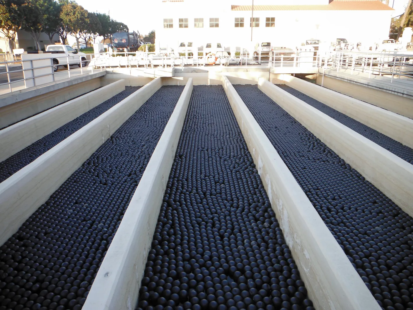 Armor Ball industrial shade balls filling rectangular concrete water-treatment channels for evaporation and algae control