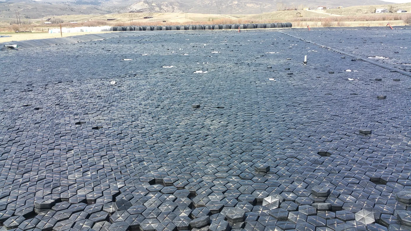 Installed Hexprotect MAX R insulated tiles floating on a heated industrial process pond