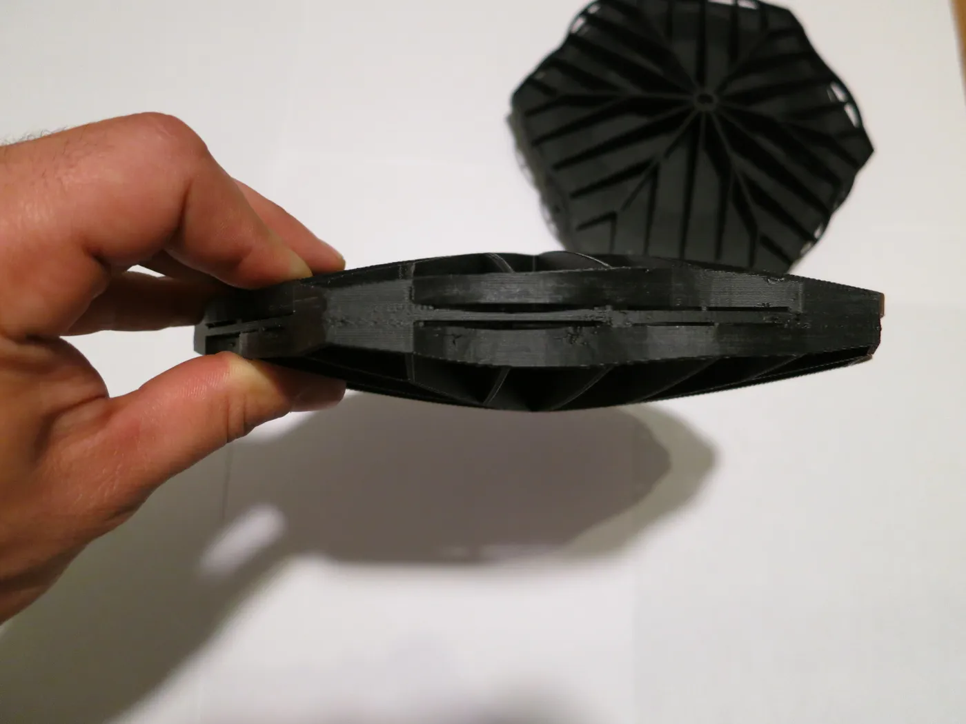 Side profile of a Hexprotect SLIM tile held in hand showing its slim low-profile design