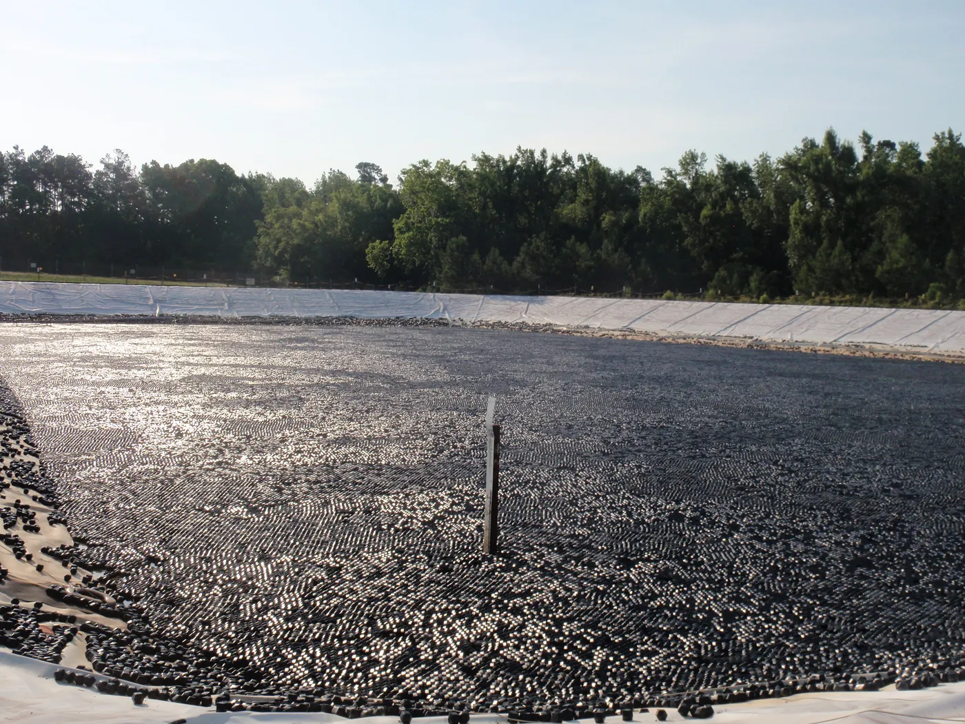 AWTT Rhombo Hexoshield modular floating cover system blanketing a large drinking water supply reservoir for evaporation control, algae prevention, and source water protection